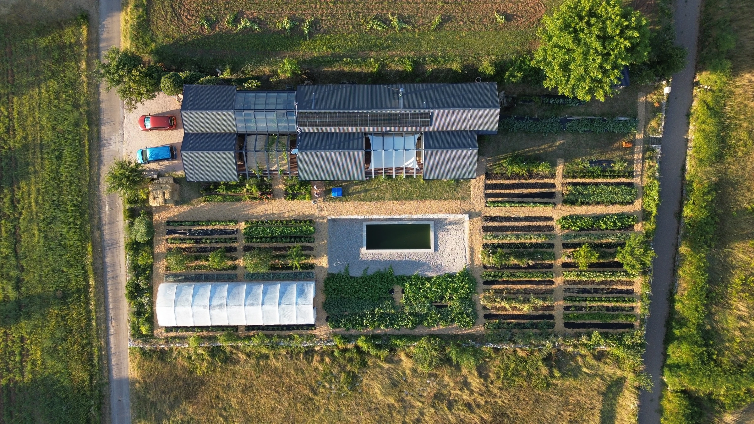 Top-down aerial of Mikrofarma Mrvica: house, garden grid, and greenhouse